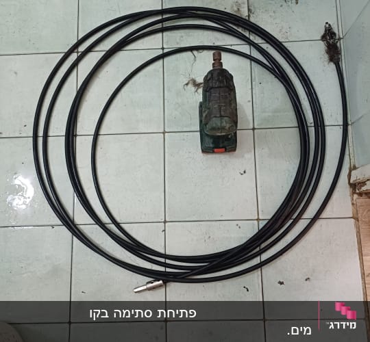 כבל אינסטלציה וכלי עבודה על רצפת חדר אמבטיה